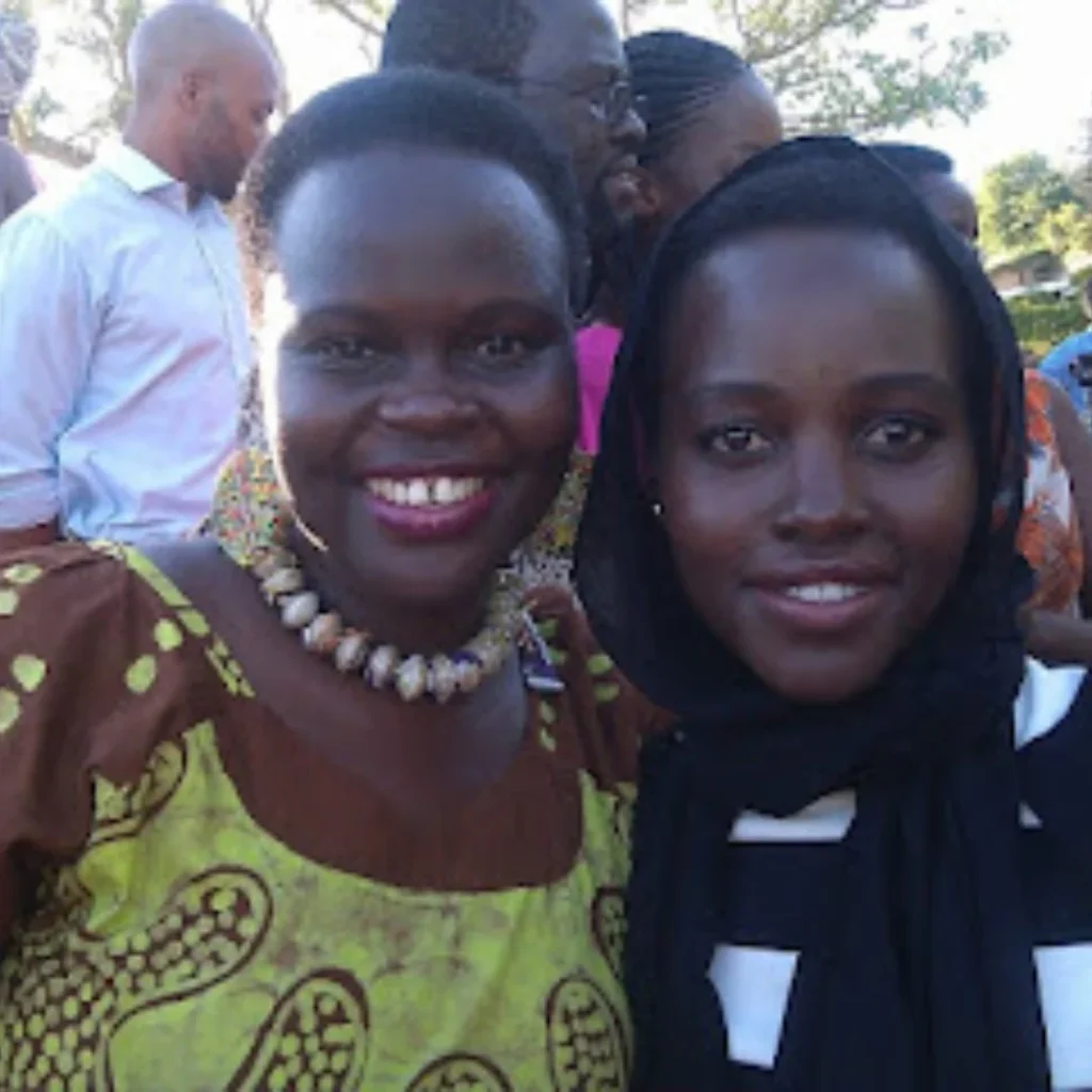 Beverley in a brown and green dress with Lupita in a black and white dress.